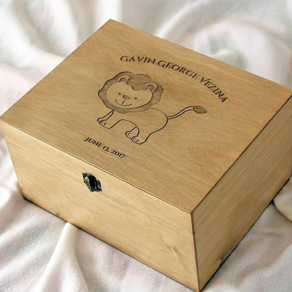 Gravure d’un motif de lion réalisée au laser CO₂ sur le couvercle d’un coffret en bois pour enfant